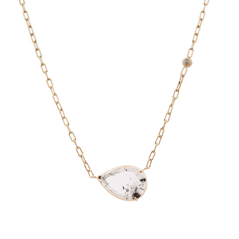 Gold necklace with a teardrop-shaped clear gemstone on a white background