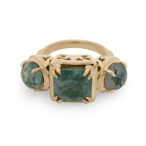 Gold ring with green gemstones on a white background