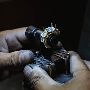 A photo of a jeweler's hands in the process making an engagement ring