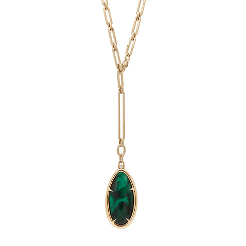 A zoomed out view of a malachite charm in a bezel setting with claw prongs set in yellow gold with white diamond accent stone on a mixed link yellow gold chain.