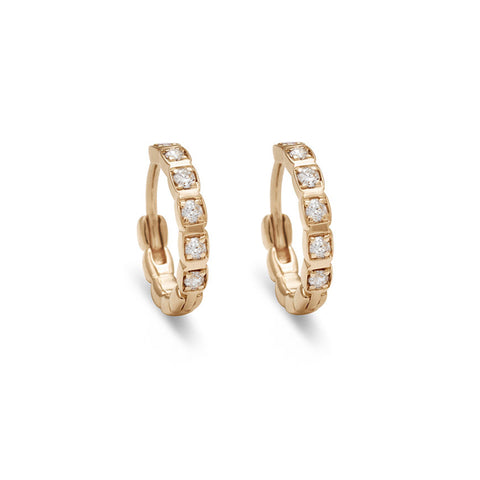 A gold pair of huggie hoops with white diamonds set in yellow gold.