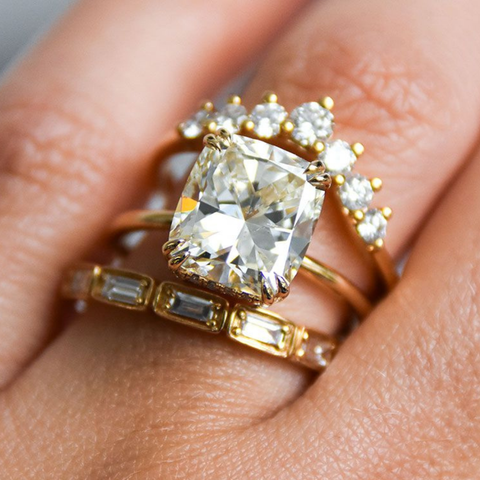 A cushion cut white diamond solitaire engagement ring set in yellow gold. 