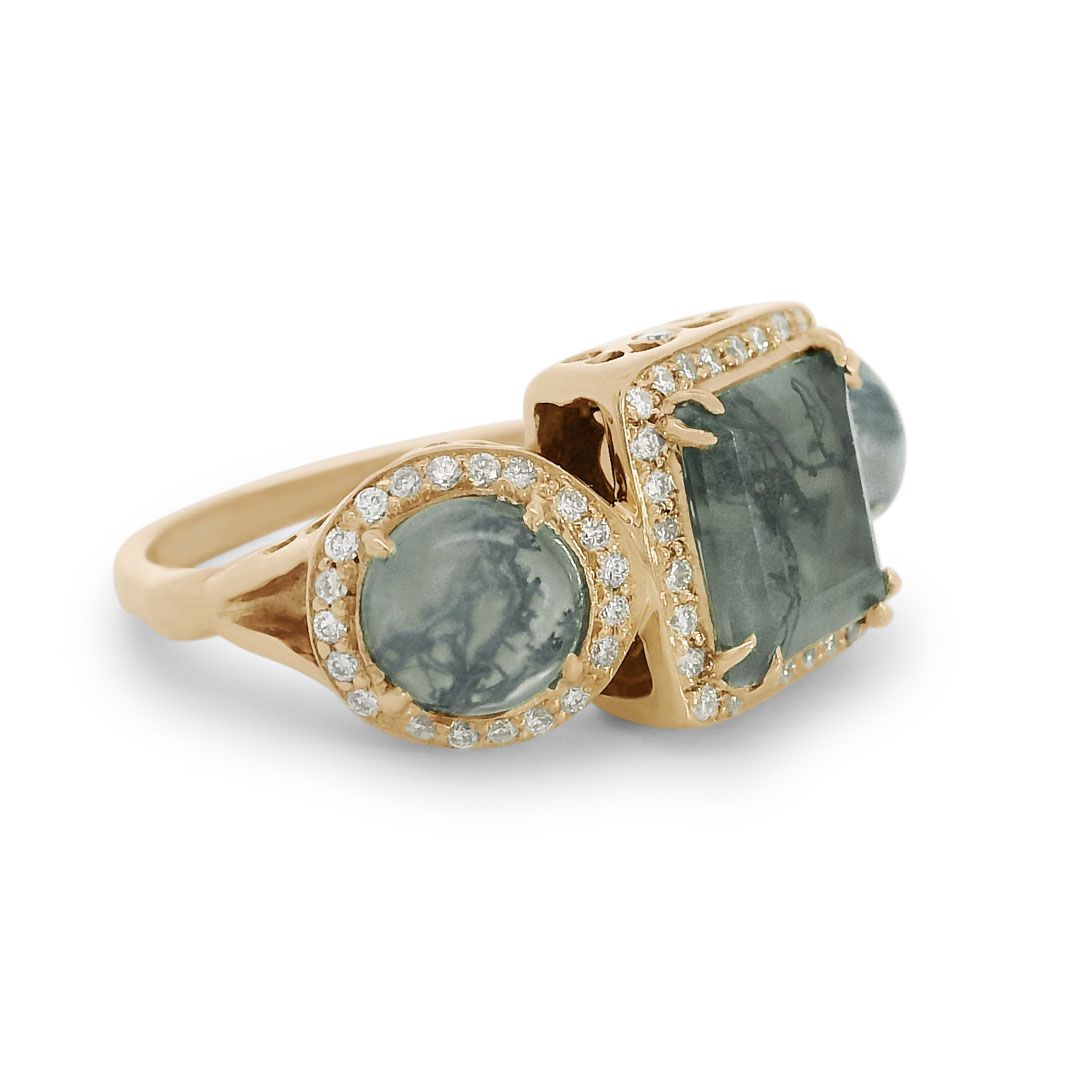 3/4 angle of a moss agate ring encircled with white diamond pavé set in 14kt yellow gold. 