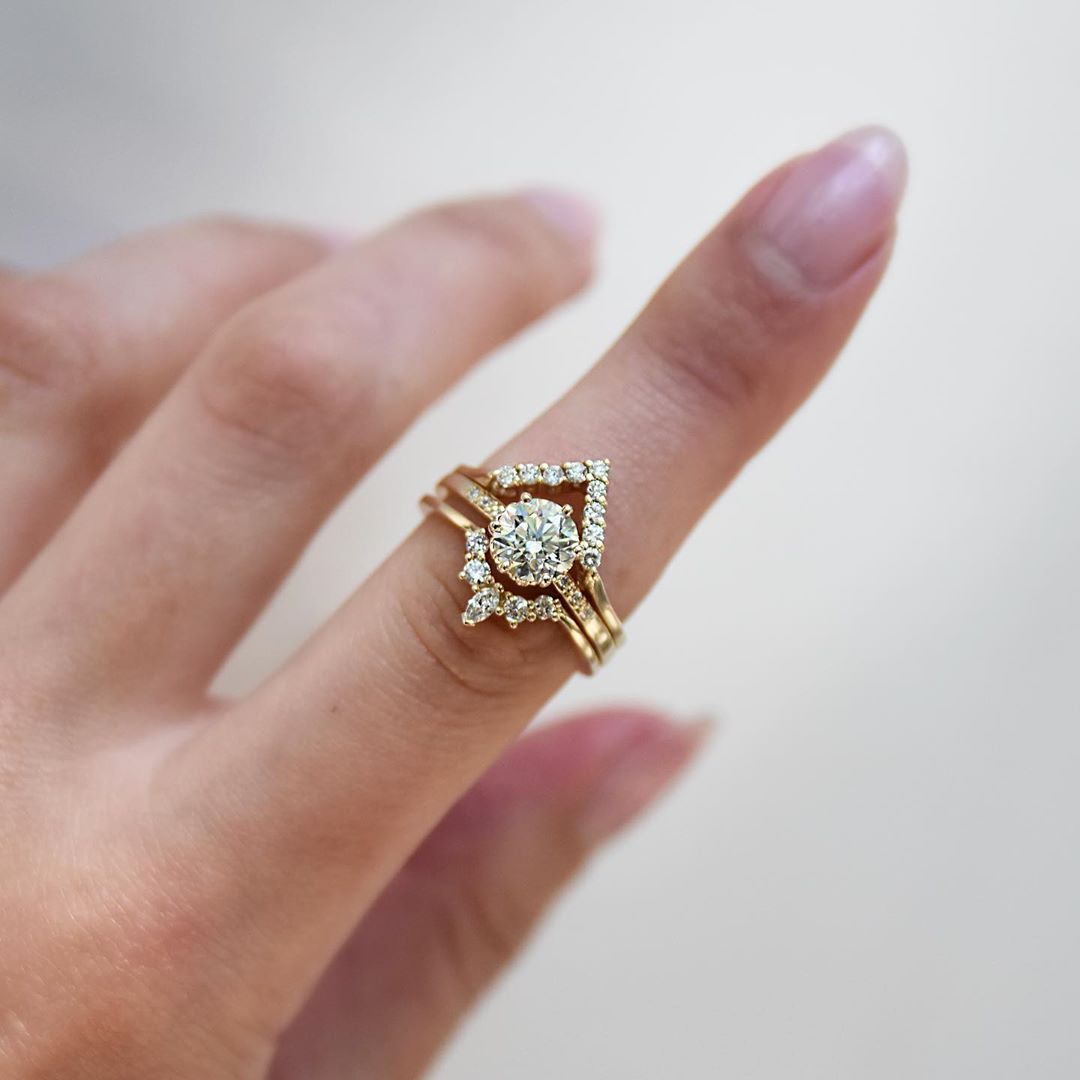 A band with 9 round white diamonds set in yellow gold above a solitaire white diamond engagment ring and a marquise white diamond band. Available in Rose Gold, Yellow Gold, White Gold.
