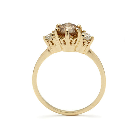 Side view of a three stone engagement ring with a round shape champagne diamond center stone with two white diamond round side stones set in yellow gold., Yellow Gold 2