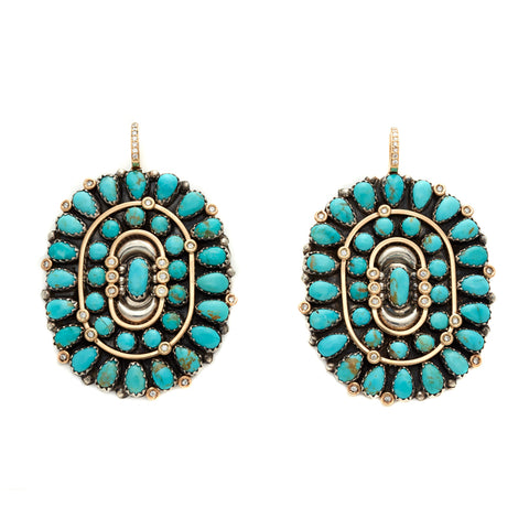 A pair of oval cabochon hoops with turquoise stones and a white diamond pave on the hook of the earring.