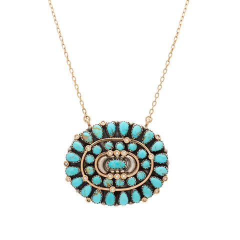 An oval cabochon charm with turquoise stones on a 16" chain in yellow gold.