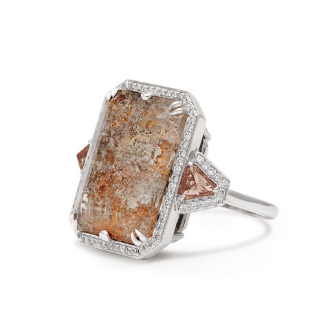Angled view of a square dolomite center stone with andalusite trillion side stones and white diamond pave halo encircling it all set in white gold.