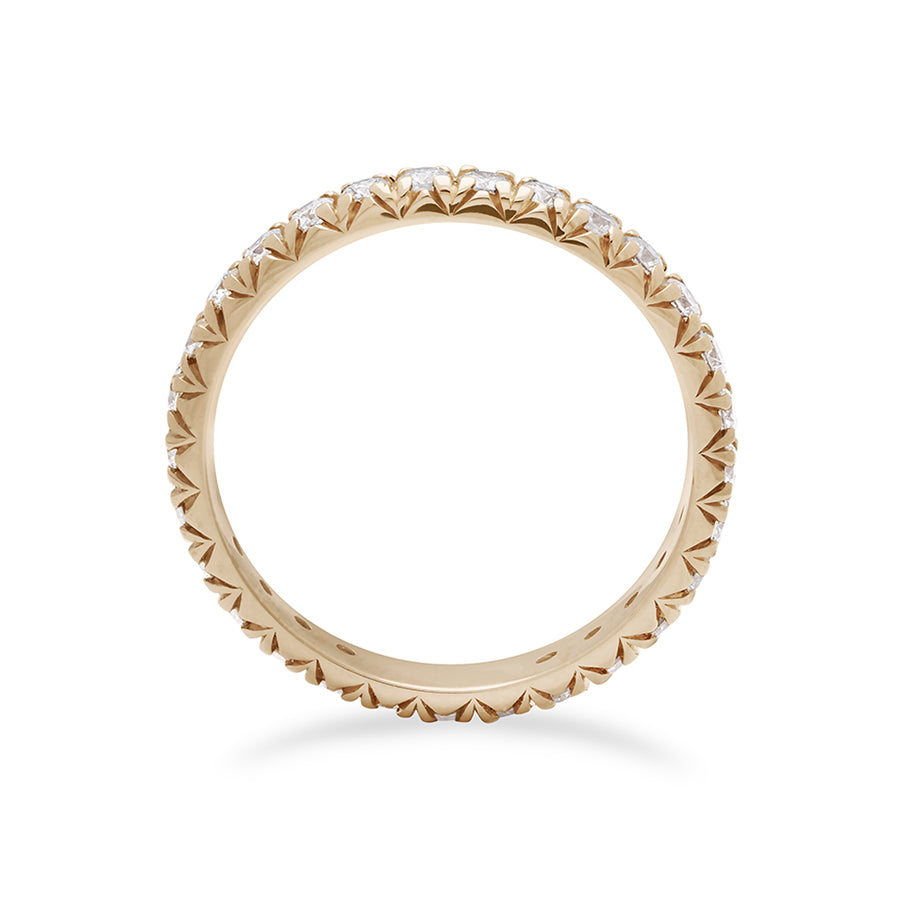 Side view of a yellow gold band with an eternity of round white diamond stones.