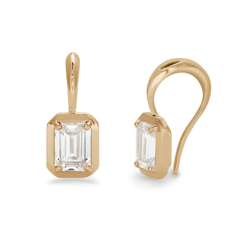 A pair of 1.50ct emerald cut white diamond earrings set in a drop from a shepherds hook in yellow gold one earring is angled.