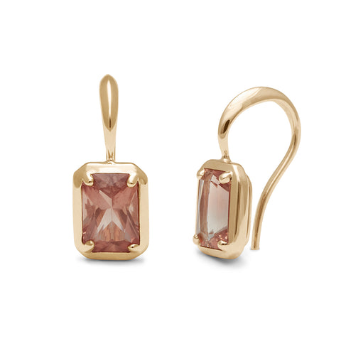 A pair of emerald cut sunstone earrings set in a drop from a shepherds hook in yellow gold one earring is angled.
