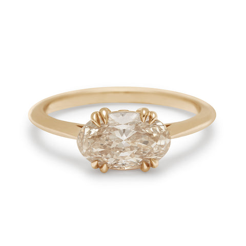 An east/west solitaire ring with an oval shape brilliant cut grey diamond stone set in yellow gold.