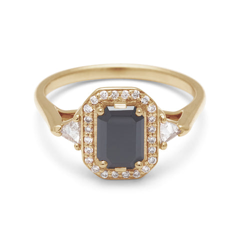 A three stone engagement ring with an emerald cut and emerald shape black diamond center stone surrounded by a white diamond pave halo with two white diamond trillion side stones set in yellow gold., Yellow Gold 2