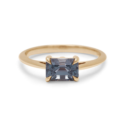 An east/west solitaire ring with an emerald shape grey spinel stone set in yellow gold., Yellow Gold