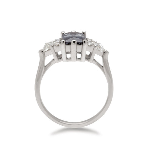 Side view of a emerald shape grey spinel center stone ring with three round white diamonds on either and two white diamond trillions on the outer edges of each side set in white gold. 2