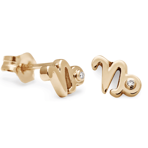 A pair of Capricorn stud earrings set in yellow gold with a white diamond accent stone with one earring angled.