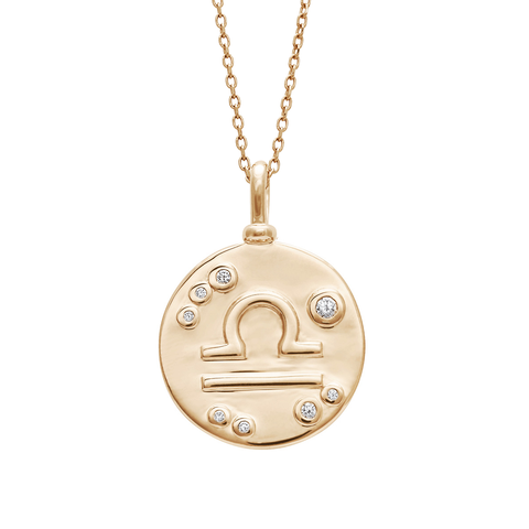 A 18mm charm with the Libra zodiac sign set in yellow gold with white diamond stones on a yellow gold chain.