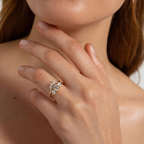 Angled view of a curved 5 grey diamond band set in yellow gold. 2