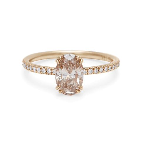 A solitaire oval champagne diamond ring with double claw prongs with white diamond pave on the band set in yellow gold., Yellow Gold