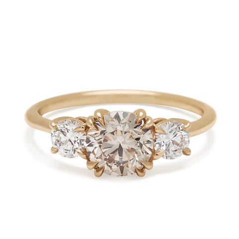 A three stone engagement ring with a round shape champagne diamond center stone with two white diamond round side stones set in yellow gold., Yellow Gold 3