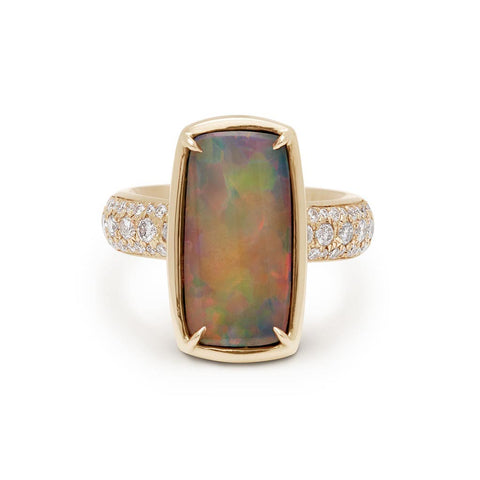 A ring with an emerald shaped black opal set in claw prongs and bezel set yellow gold with a white diamond 3/4 pave band.
