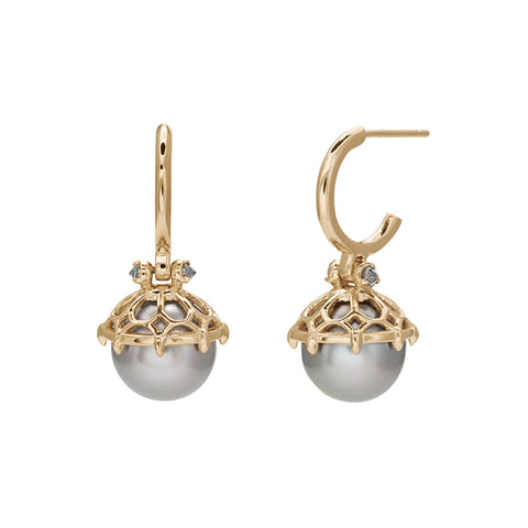 A pair of hoops with a light pearl hanging from it with grey diamond accents on either side set in yellow gold.