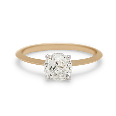 A ring with a brilliant cut and round shape Crown Jubilee white diamond center stone in a white gold basket set in a knife edge yellow gold band.