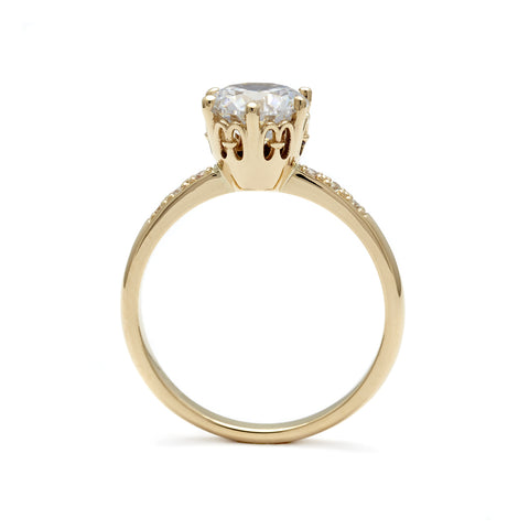 Side view of a solitaire ring with a round brilliant cut white diamond with white diamond pave on either side set in yellow gold., Yellow Gold 3