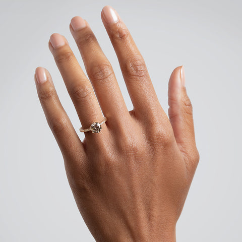 A solitaire ring with a round 1.50ct champagne diamond with white diamond pave on either side set in yellow gold on a medium-complexion on a ring finger., Rose Gold, Yellow Gold 14