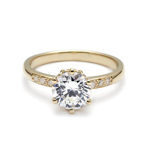 A solitaire ring with a round brilliant cut white diamond with white diamond pave on either side set in yellow gold., Yellow Gold 6