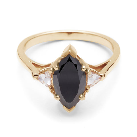 A three stone engagement ring with a marquise shape 1.25ct black diamond center stone with two white diamond trillion side stones set in yellow gold., Yellow Gold