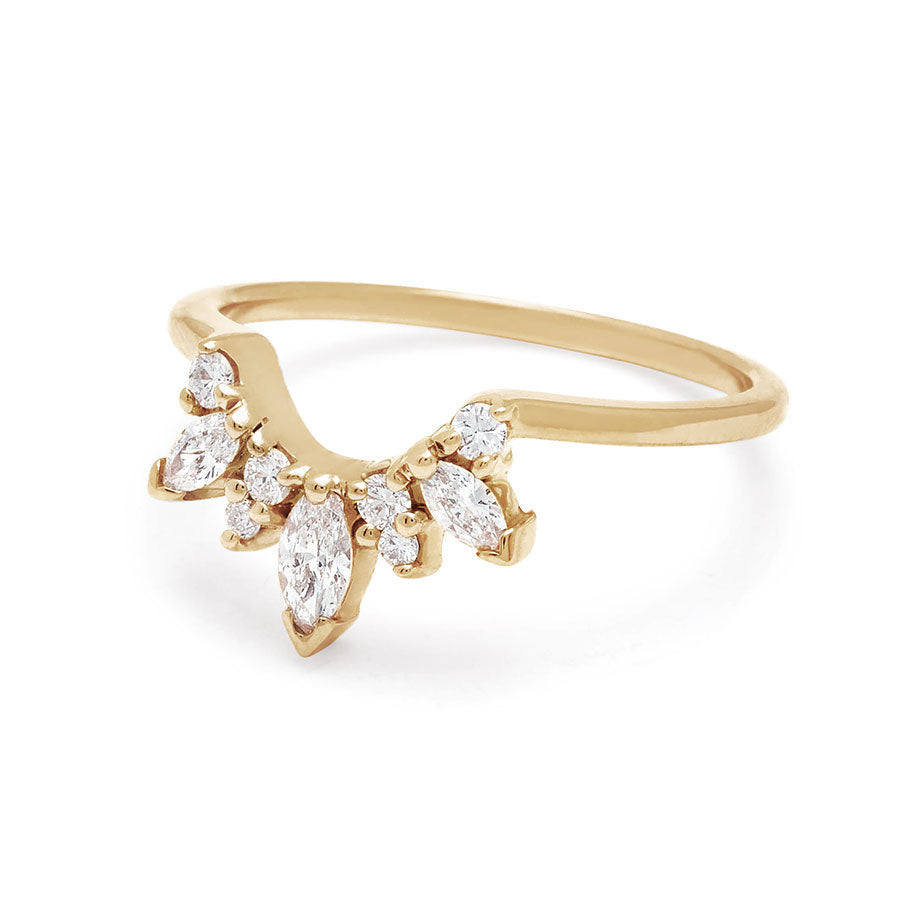 Angled view of a band with three marquise shaped white diamonds with round white diamond set in yellow gold.