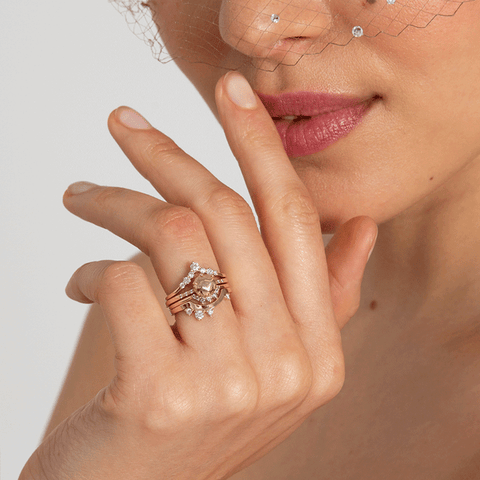 A band with white diamonds in ascending size set in yellow gold above a solid gold gemstone ring and two diamond dusted curve bands. 6