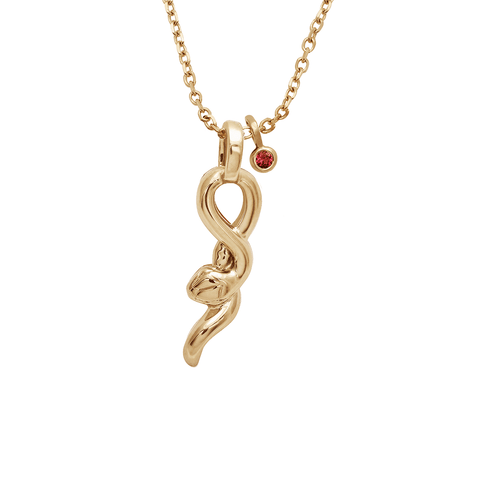 A medium sized serpent pendant set in yellow gold on a yellow gold chain with a bezel set ruby charm next to it.
