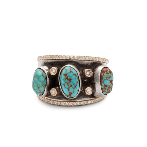 A one of a kind turquoise stone band with white diamond accent stones set in sterling silver with a double banded accent band set around with white diamond pave and yellow gold.