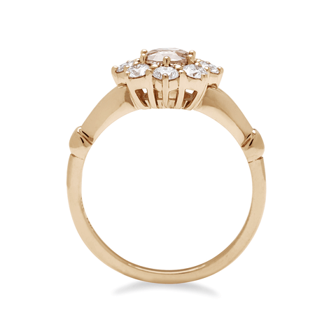 Side view of a cluster engagement ring with a rose cut champagne diamond center stone and round white diamond stones surrounding it set in yellow gold. 4