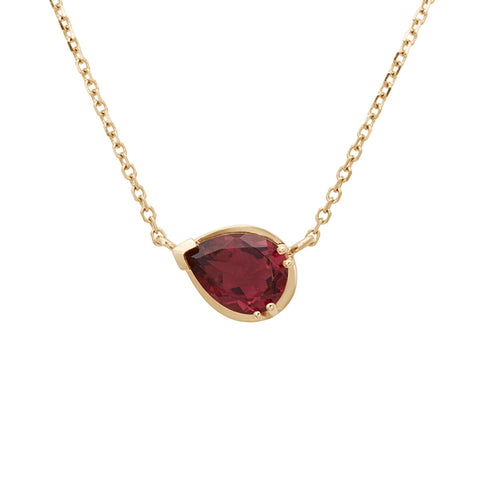 Zoomed in view of a necklace with a pear pendant with a pink tourmaline set in yellow gold with a yellow gold chain.