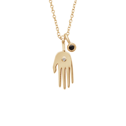 A small hand charm in yellow gold with a white diamond accent stone and a bezel set black diamond charm in yellow gold on a yellow gold chain.