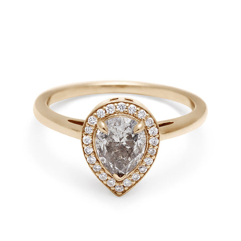 An engagement ring with a pear shape grey diamond center stone surrounded by a white diamond pave halo set in yellow gold., Yellow Gold