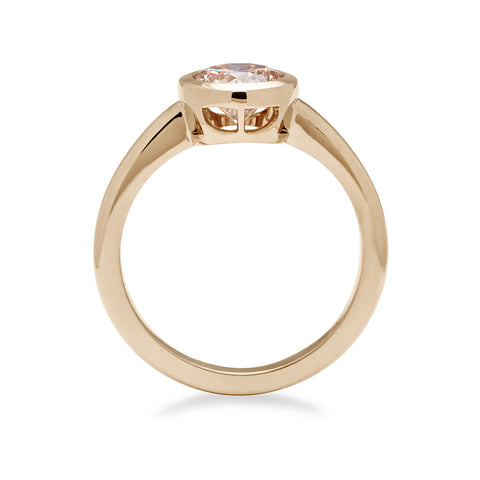 Side view of a round brilliant cut bezel set champagne diamond set in yellow gold. 3