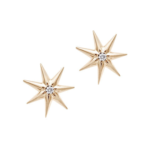 A pair of star studs with a white diamond accent stone in the center set in yellow gold.