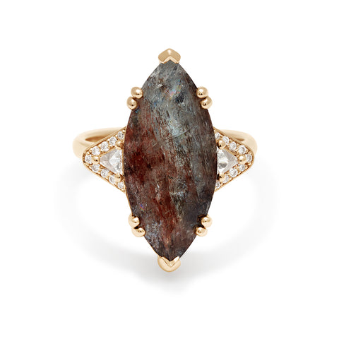 A marquise shaped ring with a quartz center stone with white diamond trillions with white diamond pave halo around them and set in yellow gold.