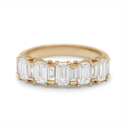 A band with alternating emerald and baguette cut white diamonds set in yellow gold.