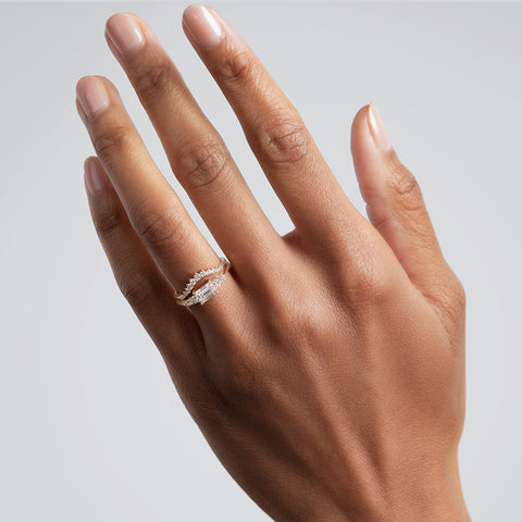 A ring with an emerald cut and shaped white diamond center stone with two round white diamonds on either side set in yellow gold below an 11 round white diamond curve band on a medium complexion model., White Gold, Rose Gold, Yellow Gold 3