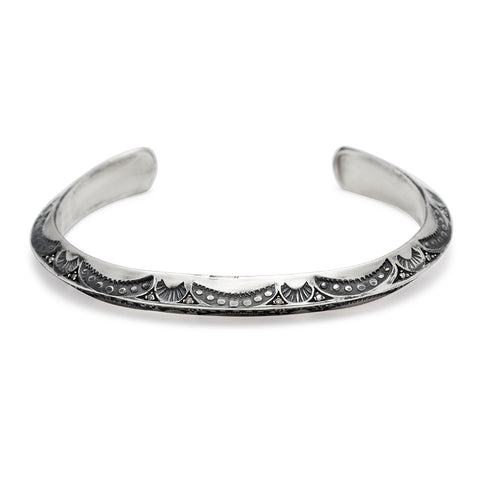 A bracelet cuff with moon shaped engravings set in sterling silver.