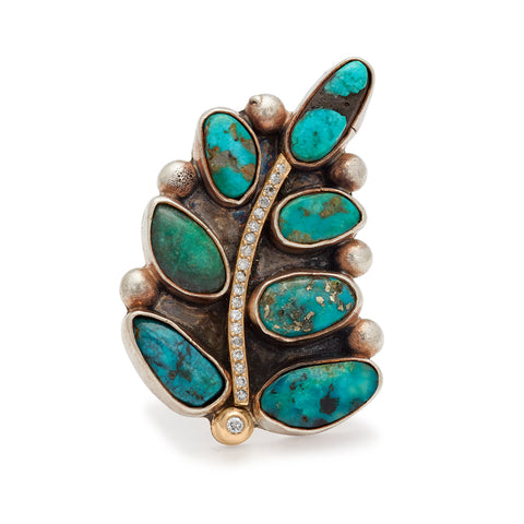 A leaf shaped, one of a kind ring with turquoise stones and white diamond pave set in yellow and white gold.