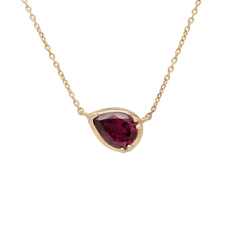 A necklace with a pear pendant with a garnet stone set in yellow gold with a yellow gold chain.