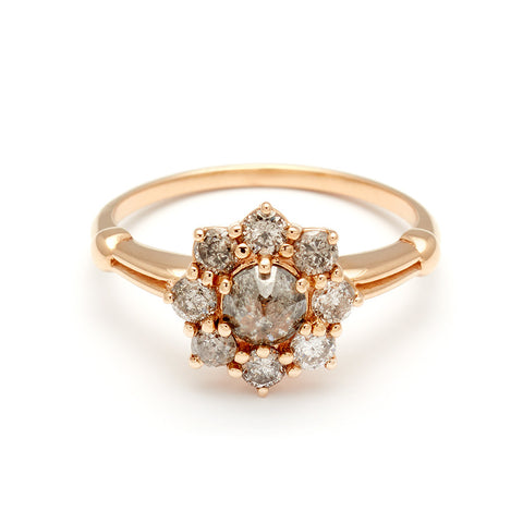 A cluster engagement ring with a rose cut grey diamond center stone and round grey diamond stones surrounding it set in yellow gold.