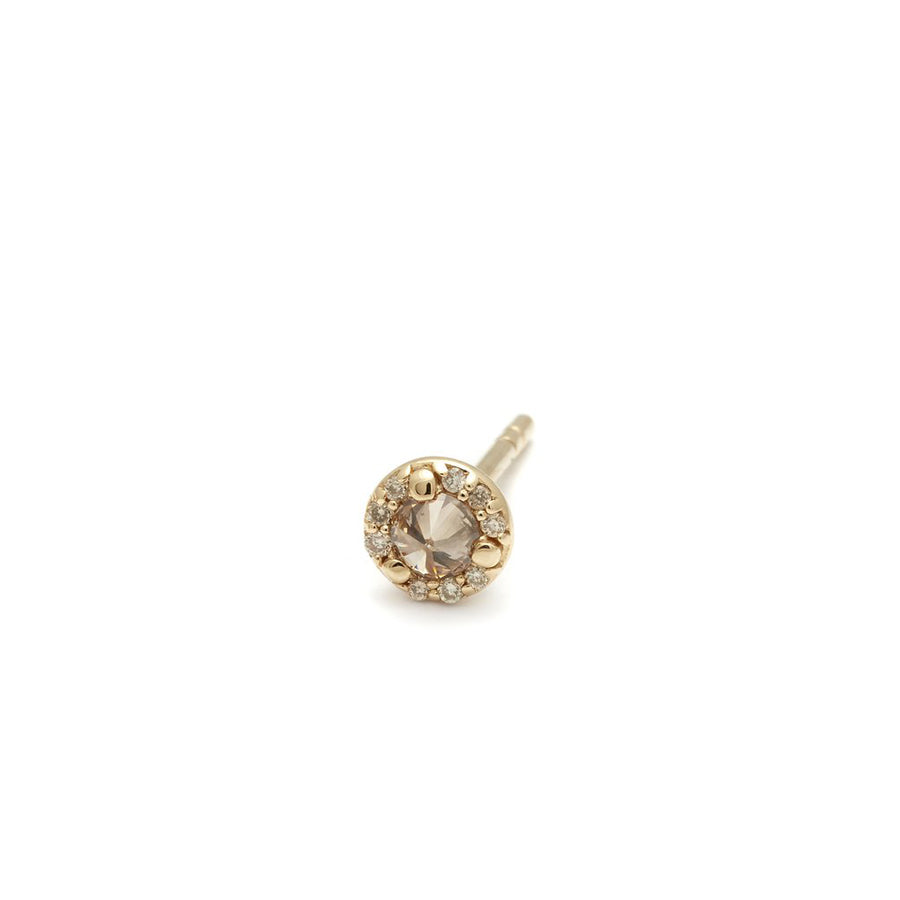 A single tiny champagne diamond center stone earring with a halo of champagne diamond set in yellow gold.