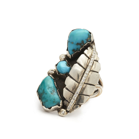 A leaf shaped ring in sterling silver with turquoise stones and white diamond pave.